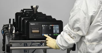 Technician operating Apex Z50 laboratory instrument touchscreen